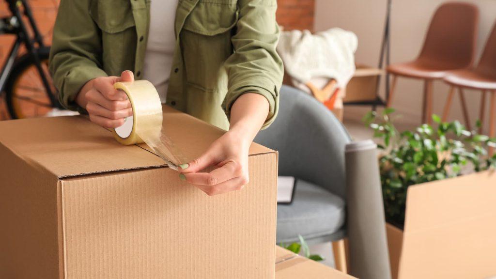 Woman packing moving box at home