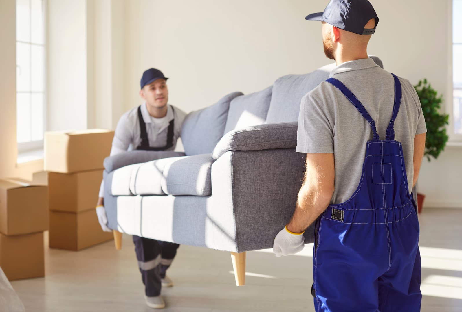 Professional House Movers Carrying Large Sofa